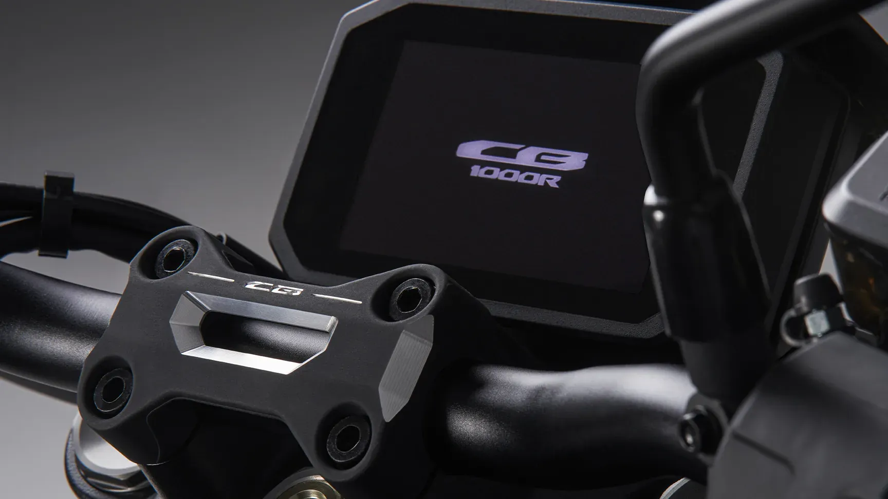 Frezowany mostek kierownicy z logo „CB” i oznaczenie CB1000R na zbiorniku