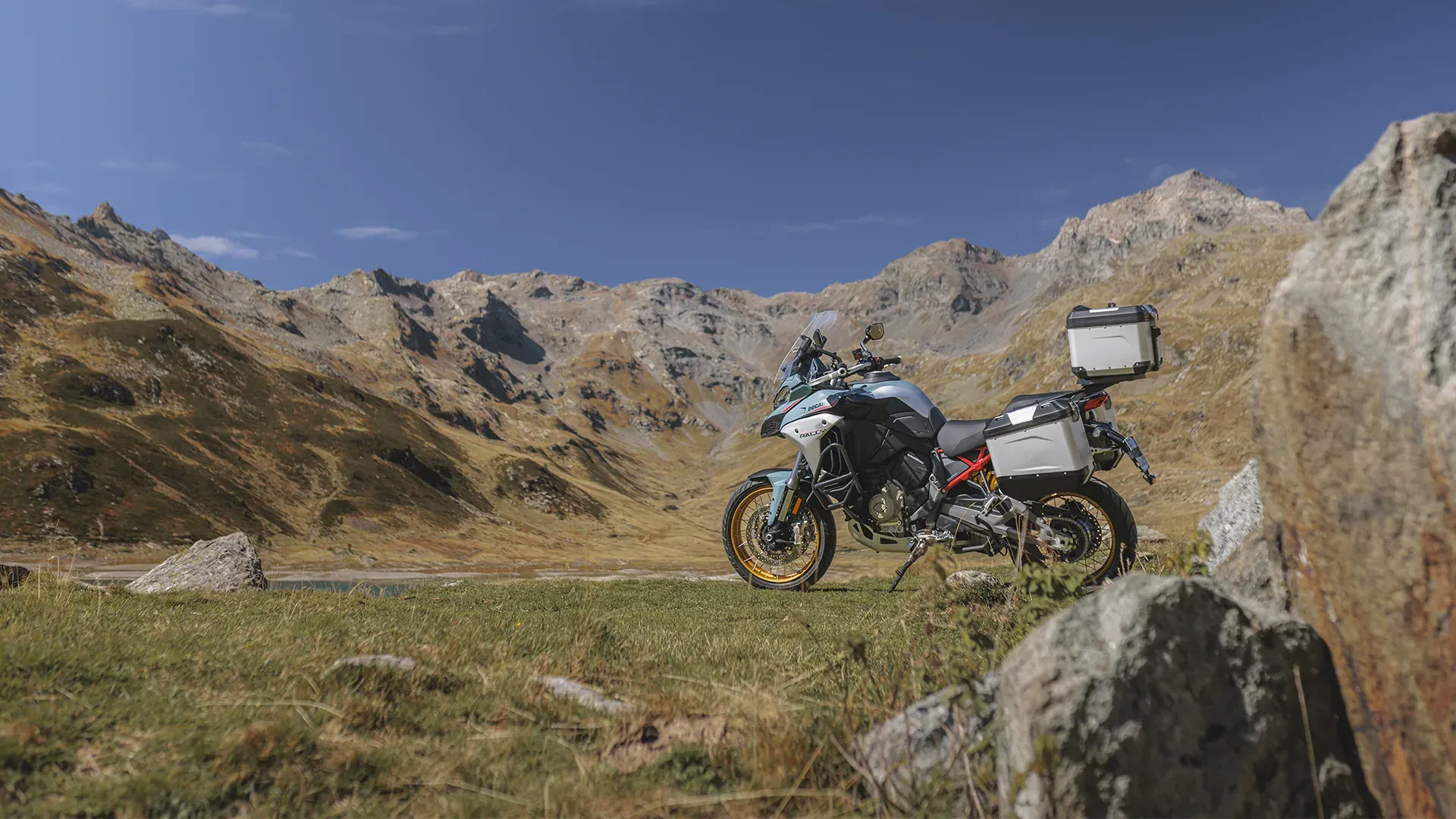 Motocykl z bagażem na tle gór — ujęcie z boku